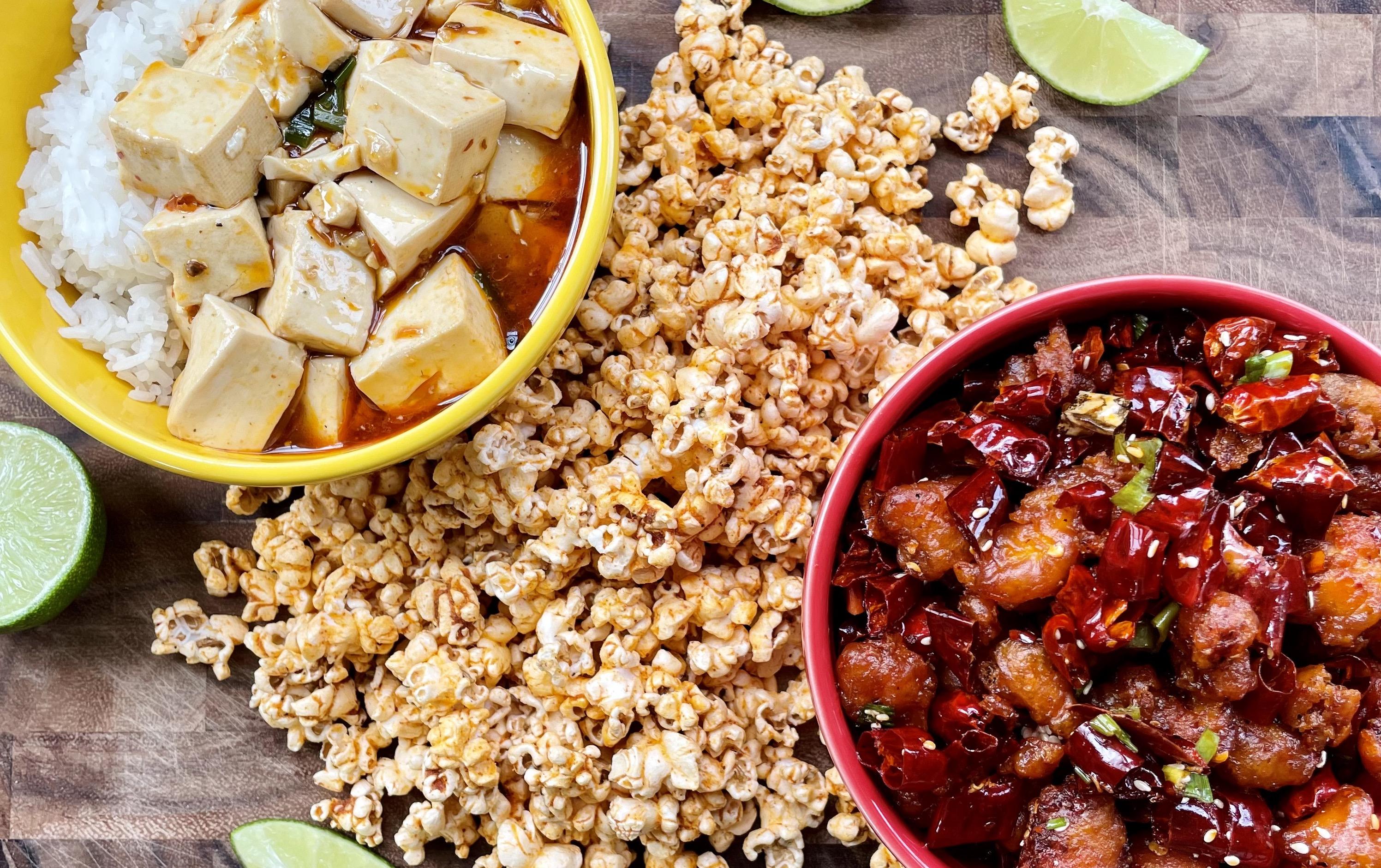 Photograph of Málà Lime craft popcorn alongside mapo tofu and lime wedges on a wooden bar top