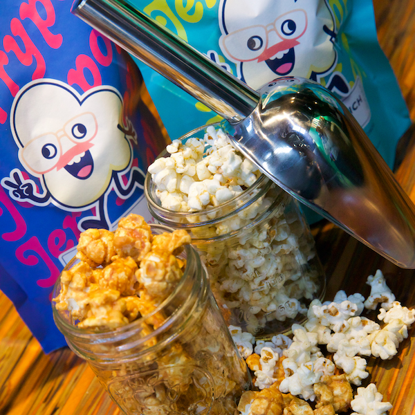 Photograph of Jerrypop craft popcorn spilling out of mason jars onto a wooden bartop.